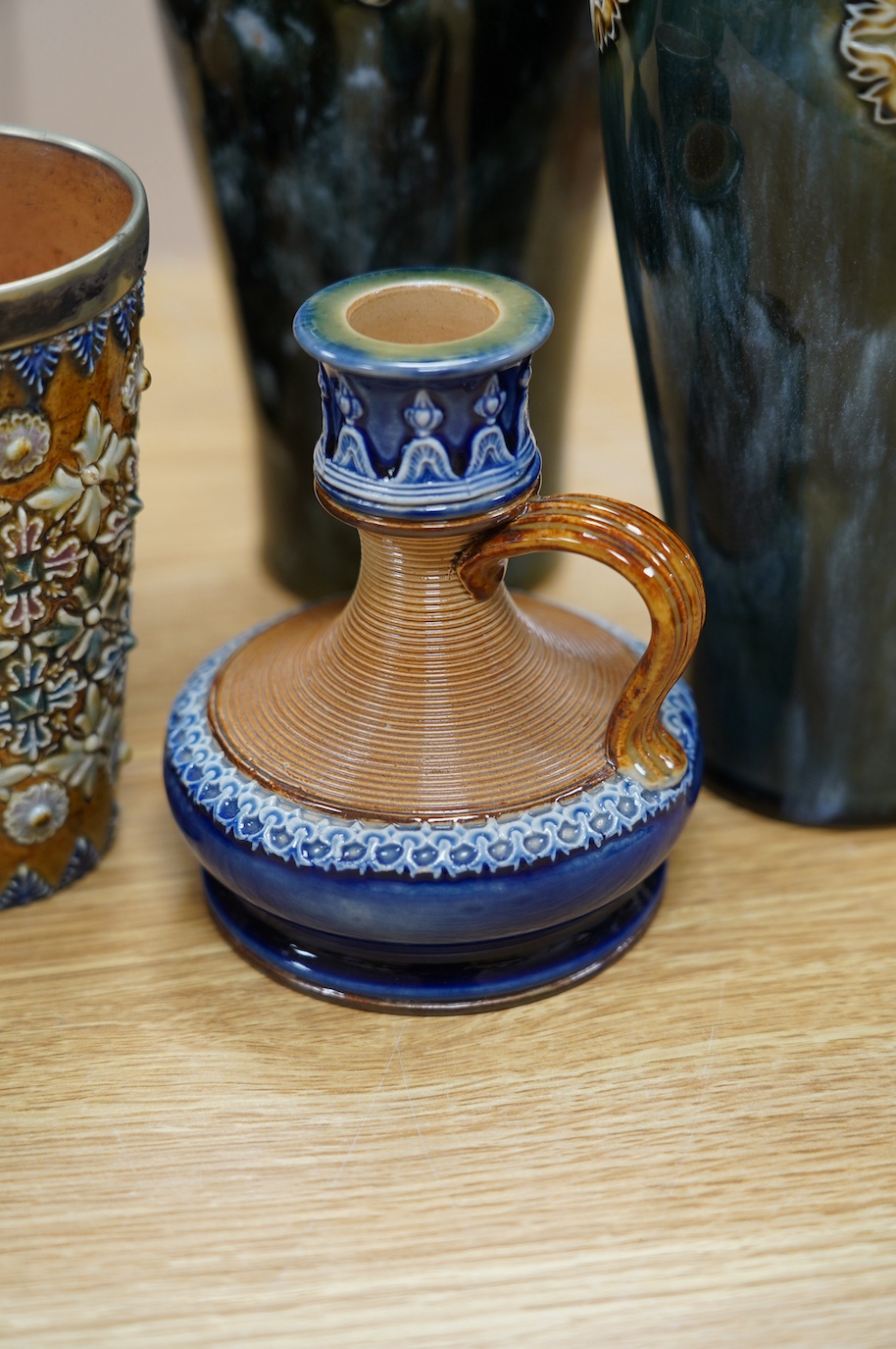 Seven Royal Doulton mixed vases etc, including two candlesticks, a pair of vases, a beaker, etc, tallest 21cm. Condition - the two handled pedestal jar has lost its lid, the other items are good